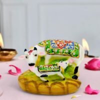 Ascension resin showpiece featuring a white Kamdhenu cow and calf statue with colorful jeweled blankets.