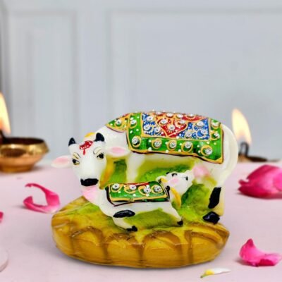 Ascension resin showpiece featuring a white Kamdhenu cow and calf statue with colorful jeweled blankets.