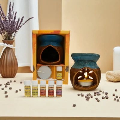 Black ceramic aroma oil burner set with lit tealight candle, two 8ml essential oil bottles, dried lavender, and gift packaging