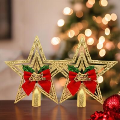Two golden Ascension Christmas star tree toppers featuring red bows and Merry Christmas text sitting on a wooden table.