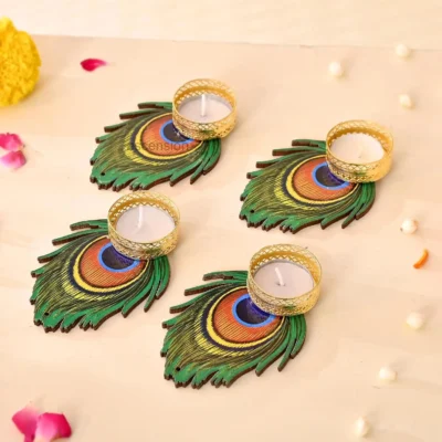 Four wooden peacock feather diya holders with golden metal cups and white wax candles on a light wooden background