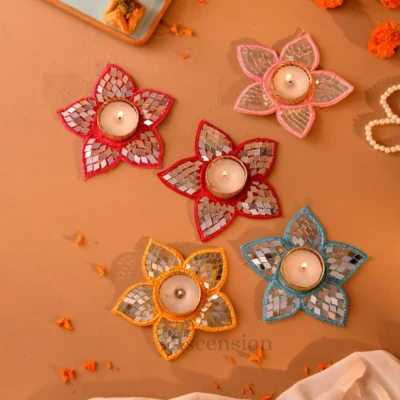 Set of five colorful star-shaped mirror work tealight holders with lit white candles