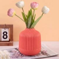 Red Plastic Flower Pot with vertical ribbed fluting on a white tabletop.