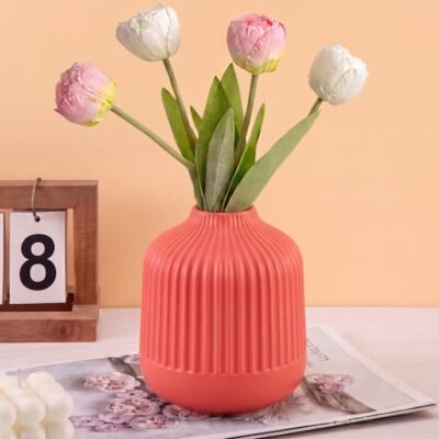 Red Plastic Flower Pot with vertical ribbed fluting on a white tabletop.