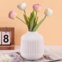 White Plastic Flower Pot with vertical ribbed fluting resting on a wooden tabletop.