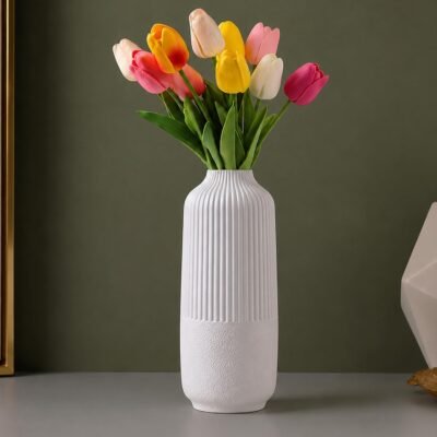 White Plastic Flower Pot with vertical ribbed fluting on top and a textured base resting on a wooden table.