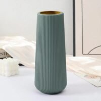 Modern sage green Plastic Flower Pot with vertical ribbed texture on a white table.