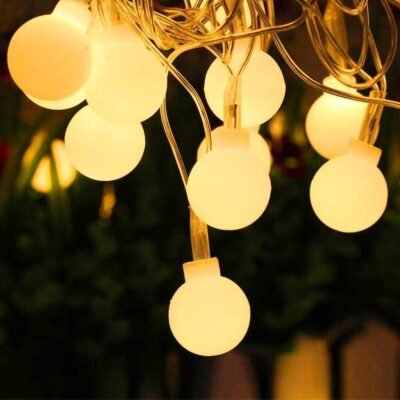 Warm white globe fairy string lights hanging and glowing softly