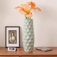 Light mint green plastic flower pot with modern geometric geometric surface texture on a table