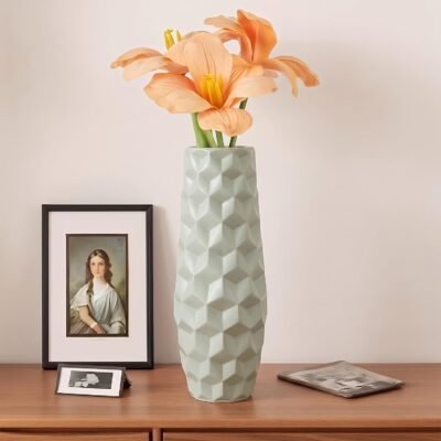 Light mint green plastic flower pot with modern geometric geometric surface texture on a table