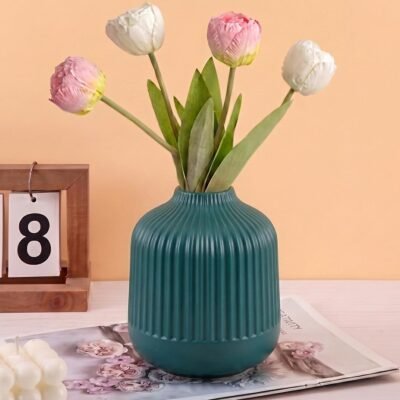 Green Plastic Flower Pot with vertical ribbed fluting on a white tabletop.