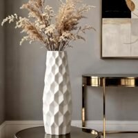 White plastic flower pot with modern geometric 3D diamond origami pattern on a wooden tabletop