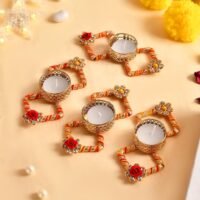 Decorative diya holder set with red orange golden thread and floral embellishments