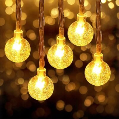 Warm white crystal ball fairy string lights hanging with a glowing bokeh background