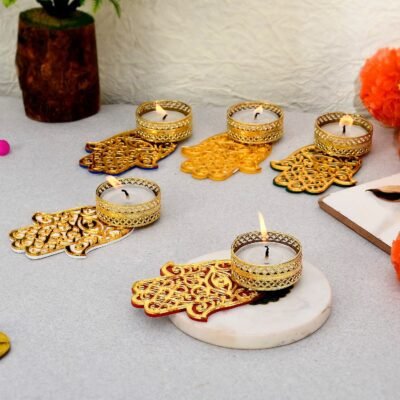 Gold Evil Eye Tealight Candle Holders shaped like Hamsa hands with lit tea lights