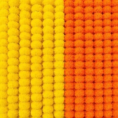 Densely packed yellow and orange marigold flower strings arranged side by side in a dual color block pattern.