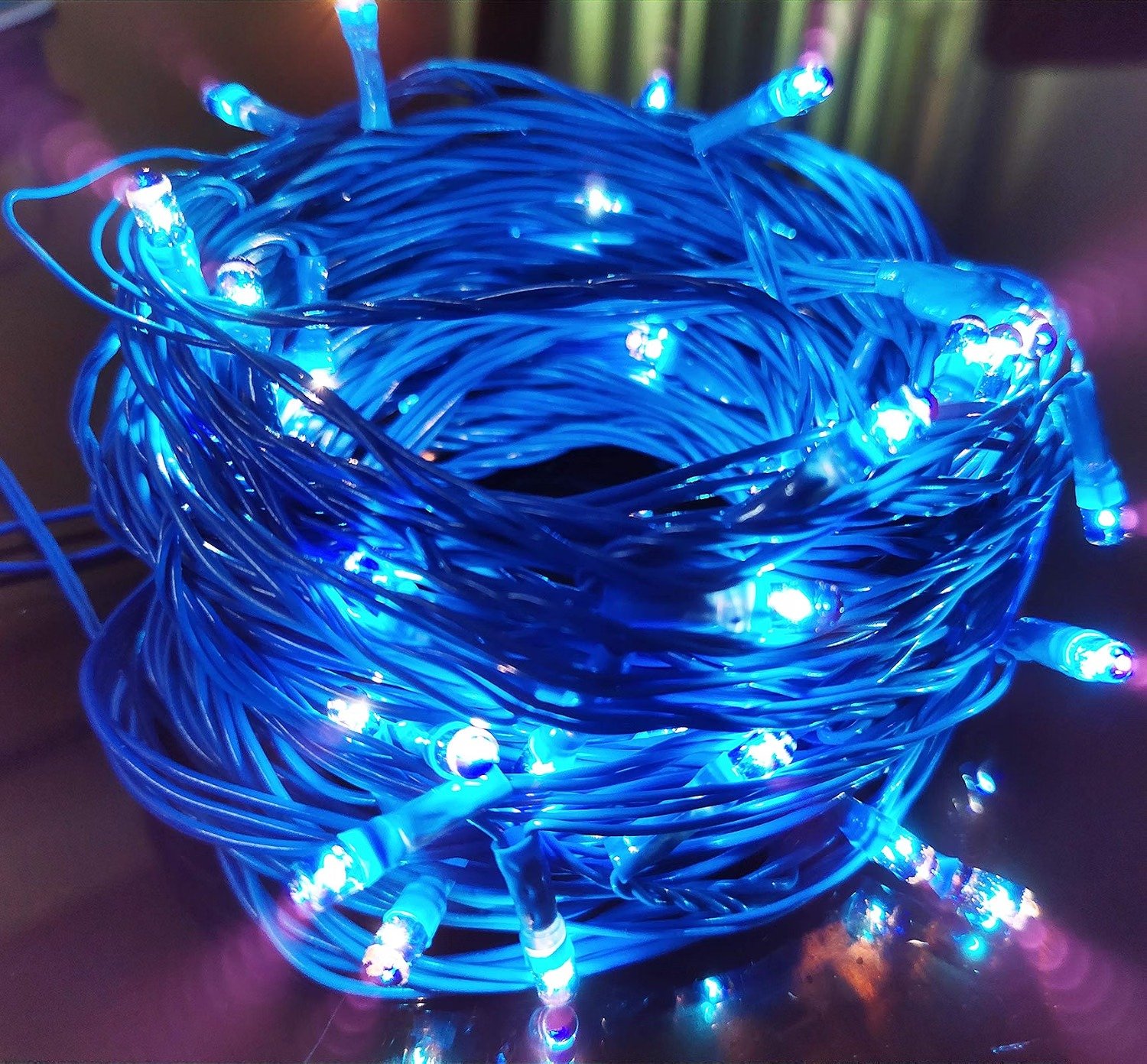 Bundled blue fairy string lights glowing brightly on a table surface