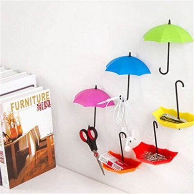 Colorful umbrella-shaped wall mount hooks holding scissors, earphones, and small desk accessories