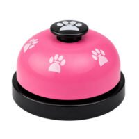 Pink dog training call bell with white paw prints on a black non-slip base.