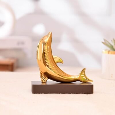 Glossy metallic golden dolphin figurine mounted on a dark rectangular wooden base