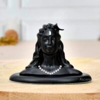 Matte black Adiyogi Shiva statue bust with rhinestone necklace on a wooden slab