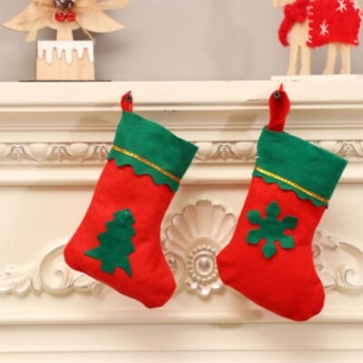Two red and green felt Christmas stockings hanging on a white mantelpiece, featuring tree and snowflake designs.