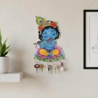 Bal Krishna Key Holder wall mount featuring blue Bal Krishna playing a flute while sitting on a pink lotus flower on a beige wall.