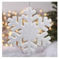 A large white glitter snowflake ornament hanging by a silver string against a background of warm fairy lights.