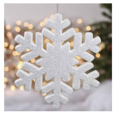 A large white glitter snowflake ornament hanging by a silver string against a background of warm fairy lights.