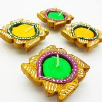 Ascension handcrafted terracotta wax diya set painted in gold with green and yellow wax filling.