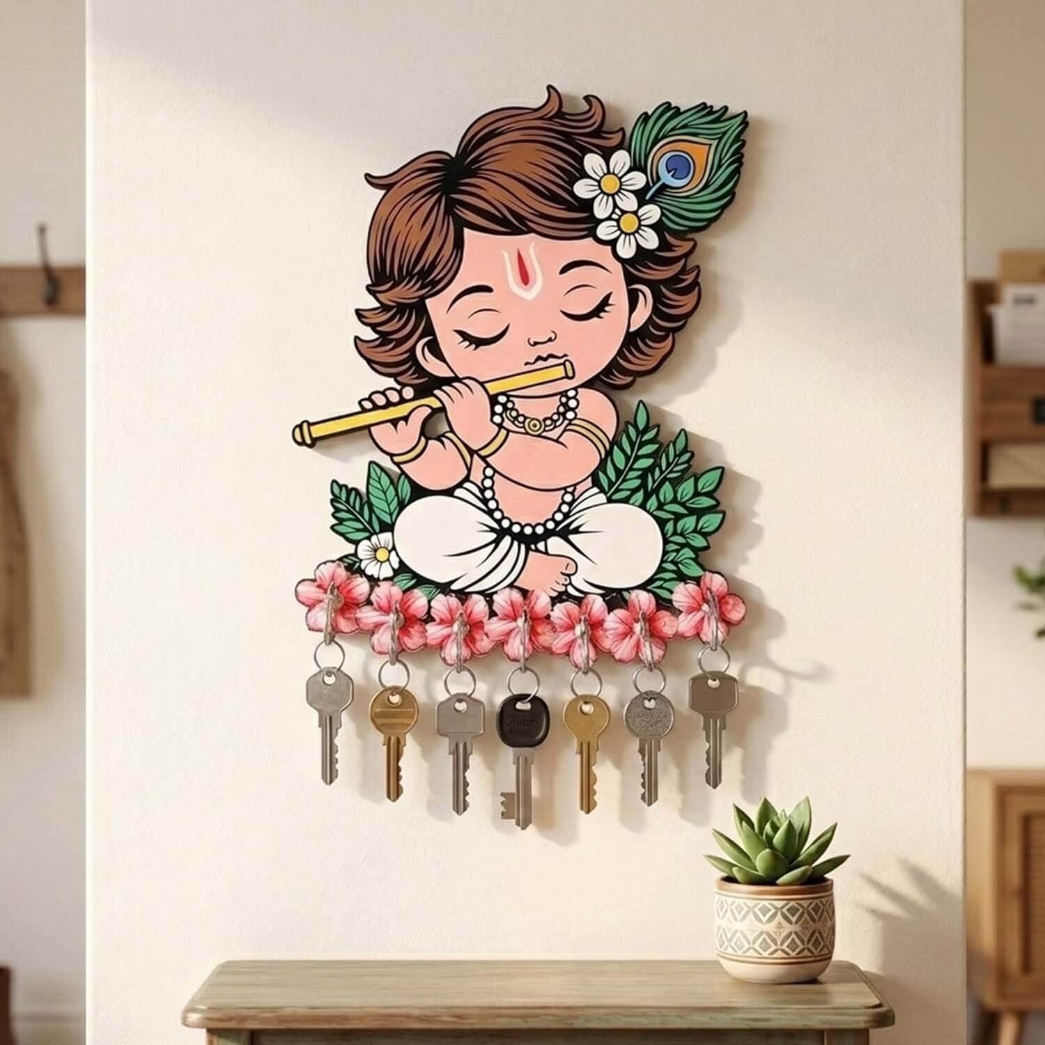 Krishna Wooden Key Holder mounted on a beige wall featuring a cute fair-skinned Bal Krishna playing flute with keys hanging on pink flower hooks.
