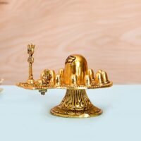 Golden brass Dwadash Jyotirlinga Shivling idol with Nandi bull and Trishul on white surface