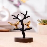 Golden love birds perched on a black tree branch showpiece mounted on a circular dark base