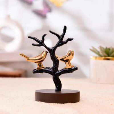 Golden love birds perched on a black tree branch showpiece mounted on a circular dark base