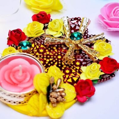 Ascension floral tealight candle holder decorated with yellow and red mini roses, gold accents, and a pink candle.