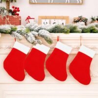 Four classic red Christmas stockings with bright white cuffs hanging in a row from a decorated white fireplace mantel.