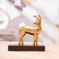 Metallic golden deer figurine standing on a rectangular dark brown wooden base