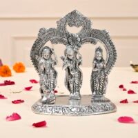 Silver-plated Ram Darbar idol depicting Lord Ram, Sita, Laxman, and Hanuman under an ornamental archway on a beige surface