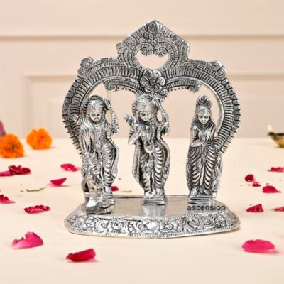 Silver-plated Ram Darbar idol depicting Lord Ram, Sita, Laxman, and Hanuman under an ornamental archway on a beige surface