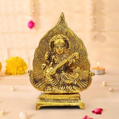 Antique golden brass Goddess Saraswati idol playing veena seated on a leaf motif pedestal