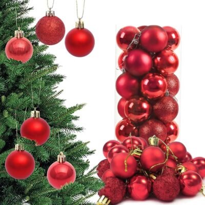 A collection of red Christmas baubles in shiny, matte, and glitter finishes hanging on a tree and overflowing from a clear container.