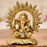 Golden brass Sun Ganesha idol with radiant sun ray halo on a wooden surface