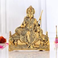 Golden brass Ram Lalla idol holding a bow and seated on a royal throne on a white surface