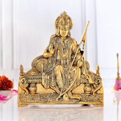 Golden brass Ram Lalla idol holding a bow and seated on a royal throne on a white surface