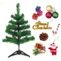 Ascension mini artificial green Christmas tree displayed alongside festive ornaments including glitter baubles, mini gifts, drums, and a Santa figure.