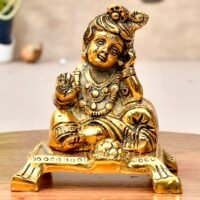 Golden brass Laddu Gopal idol sitting on a chowki platform resting head on hand