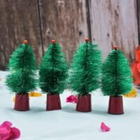 Four miniature green Christmas trees with red bases and tiny red toppers arranged in a row on a white surface.