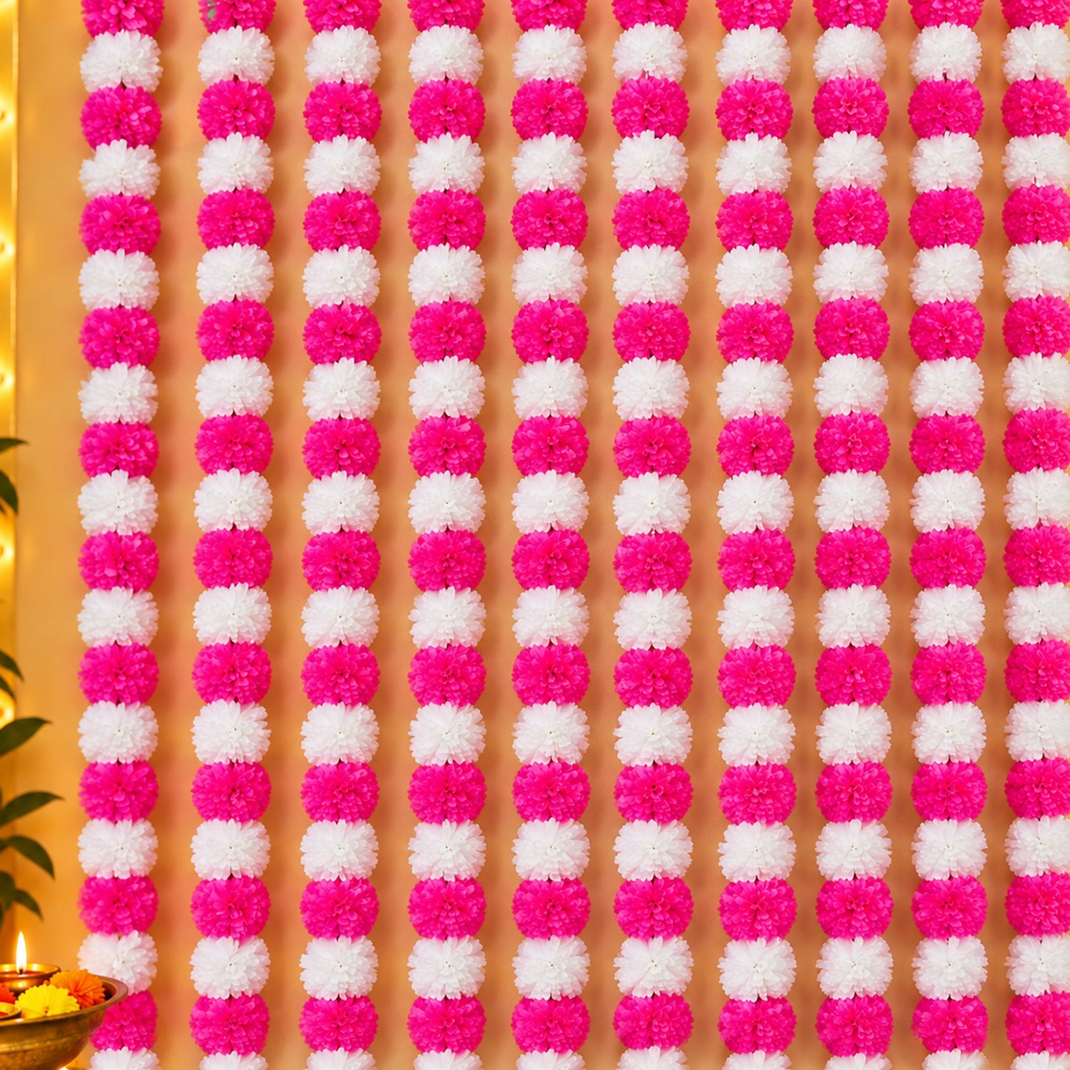 Pink Marigold Garland Strings pack of 10 hung vertically side by side as a full wall backdrop with pink and white pom-pom flowers.