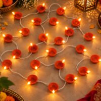 Terracotta diya LED string lights illuminated on floor for Diwali decor