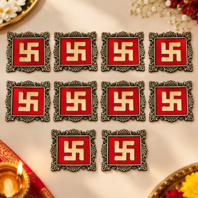 Ten square red and gold Swastik decor tiles arranged neatly on a festive beige surface.